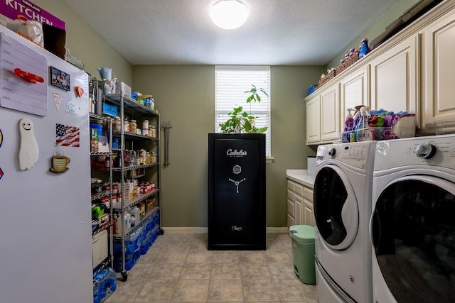 laundry room featuring baseboards, independent washer and dryer, and cabinet space