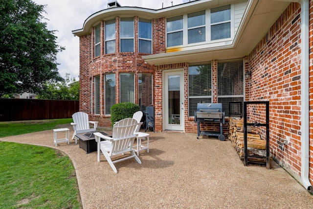 view of patio featuring fence and a grill