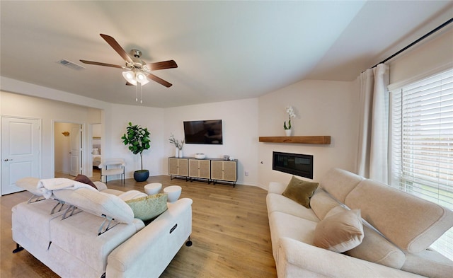 living area featuring plenty of natural light, ceiling fan, wood finished floors, and visible vents