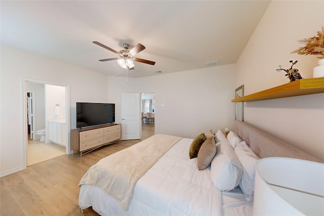 bedroom with ensuite bathroom, light wood finished floors, ceiling fan, and visible vents