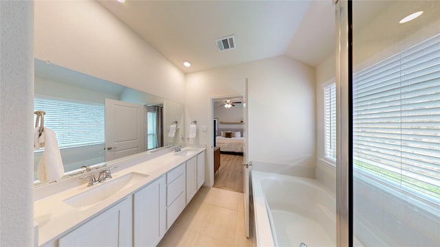 full bathroom featuring double vanity, a garden tub, visible vents, a sink, and connected bathroom