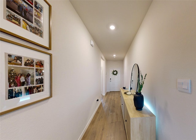 hallway featuring recessed lighting, baseboards, and light wood finished floors
