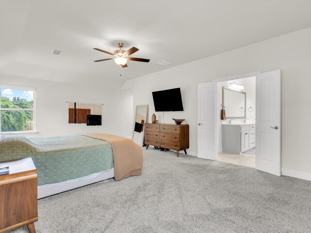 bedroom featuring a ceiling fan, light carpet, and ensuite bathroom