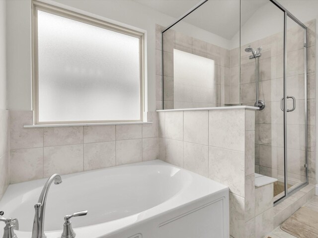 full bathroom featuring a garden tub and a stall shower
