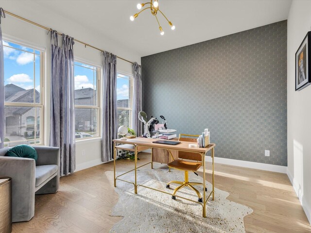 office with baseboards, an accent wall, and wallpapered walls