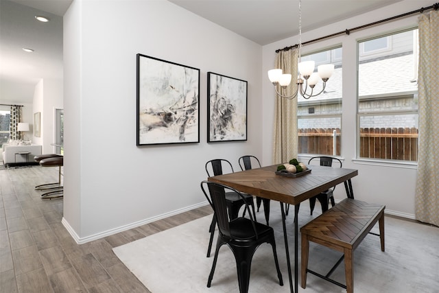 dining room featuring baseboards, recessed lighting, wood finished floors, and a chandelier