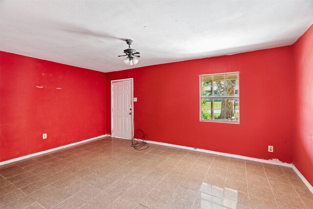unfurnished room featuring a ceiling fan and baseboards