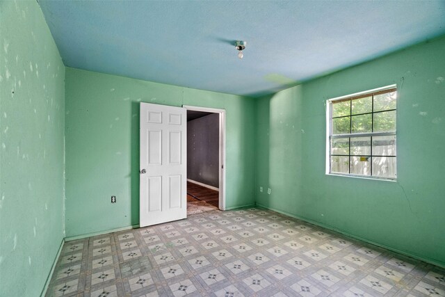 unfurnished bedroom featuring light floors and baseboards