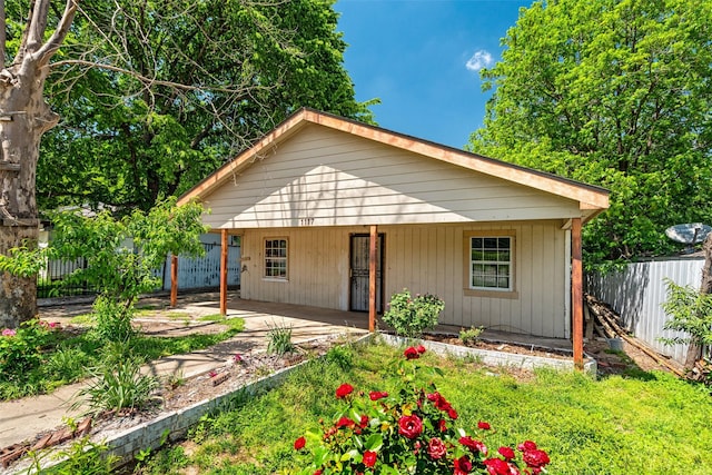 view of front of property featuring fence and a porch