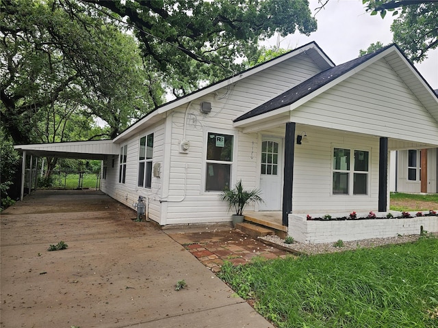 bungalow-style home with a porch, concrete driveway, and a carport