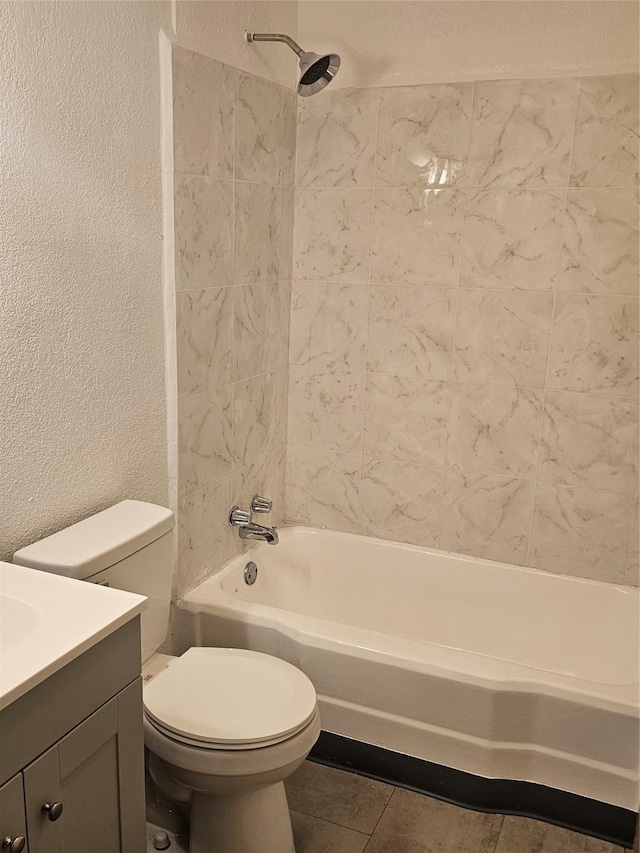 bathroom featuring vanity, tile patterned flooring, a textured wall, toilet, and shower / washtub combination