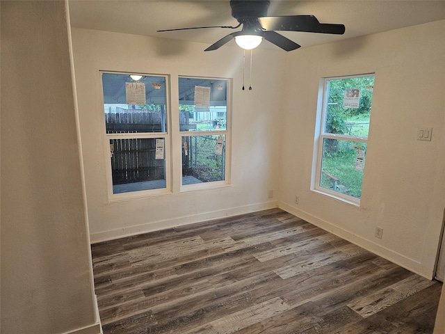 spare room with baseboards, ceiling fan, and wood finished floors