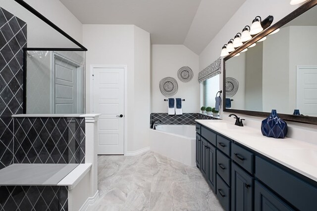 bathroom featuring double vanity, marble finish floor, a bath, a sink, and vaulted ceiling