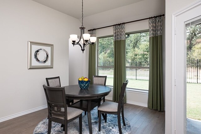 dining space featuring baseboards, a notable chandelier, and dark wood-style floors