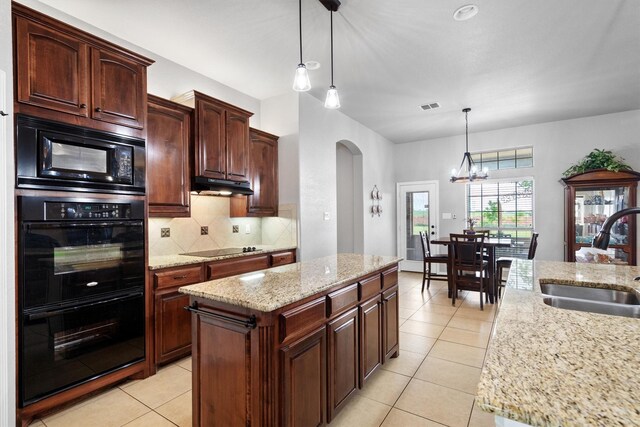 kitchen with backsplash, arched walkways, a sink, black appliances, and under cabinet range hood