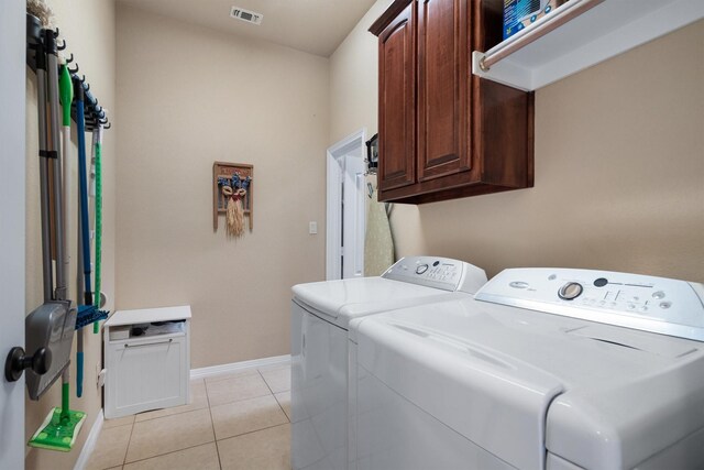 laundry area featuring visible vents, cabinet space, light tile patterned floors, baseboards, and separate washer and dryer