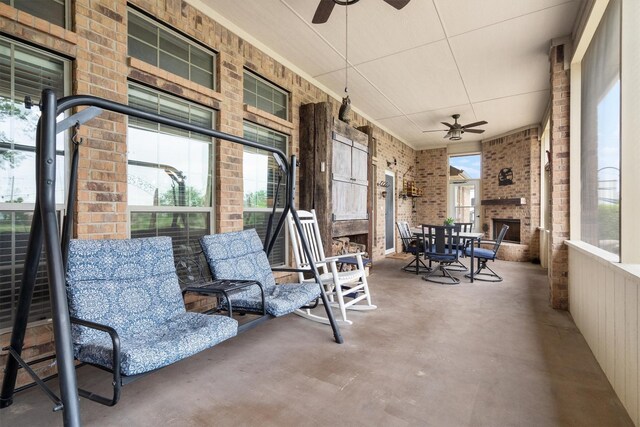 view of patio featuring ceiling fan, a porch, and a large fireplace