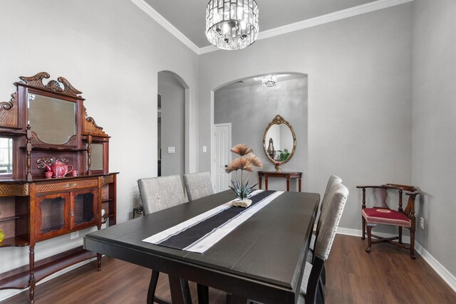 dining room featuring crown molding, arched walkways, wood finished floors, and a chandelier