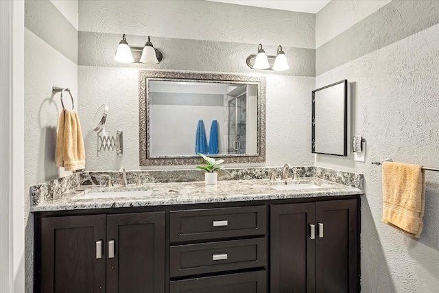 bathroom with a sink, a textured wall, and double vanity