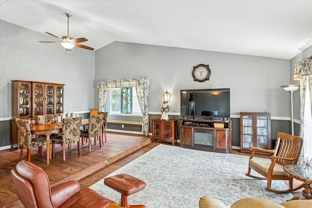 living room featuring baseboards, a ceiling fan, wood finished floors, and lofted ceiling