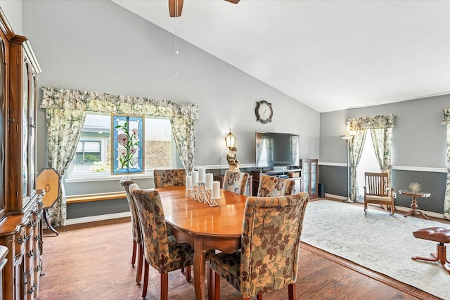 dining room with plenty of natural light, ceiling fan, wood finished floors, and high vaulted ceiling