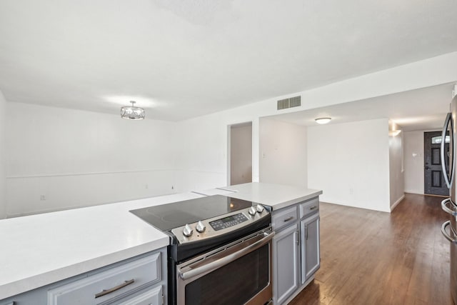 kitchen featuring visible vents, dark wood finished floors, stainless steel range with electric stovetop, gray cabinetry, and light countertops