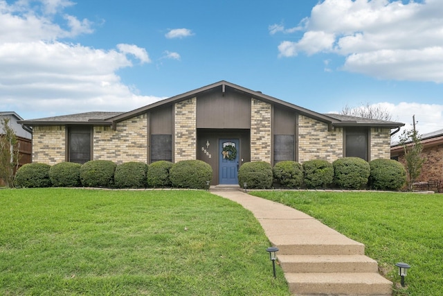 mid-century modern home featuring brick siding and a front yard