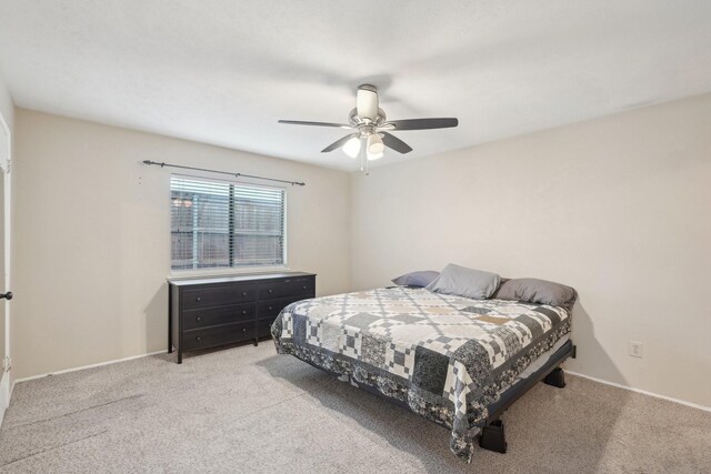 bedroom featuring light colored carpet, baseboards, and ceiling fan