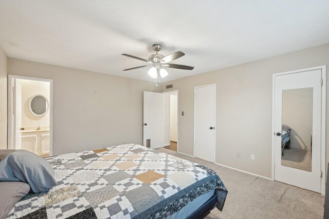 bedroom featuring ceiling fan, light colored carpet, baseboards, ensuite bathroom, and visible vents