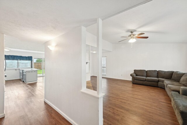 living area featuring baseboards, ceiling fan, and wood finished floors