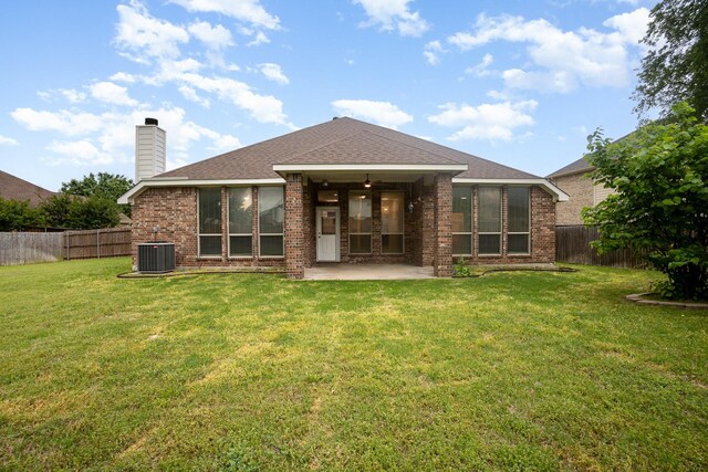 rear view of house featuring brick siding, a fenced backyard, a patio area, central air condition unit, and a yard