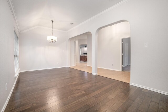 unfurnished dining area featuring arched walkways, a notable chandelier, ornamental molding, and hardwood / wood-style floors