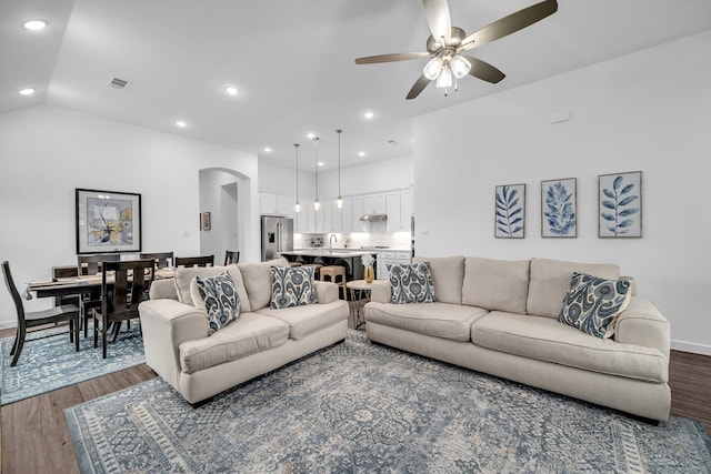 living area with arched walkways, a ceiling fan, recessed lighting, wood finished floors, and visible vents