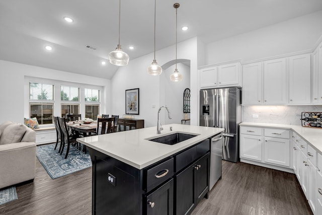 kitchen with visible vents, a sink, light countertops, dark cabinets, and dark wood-type flooring