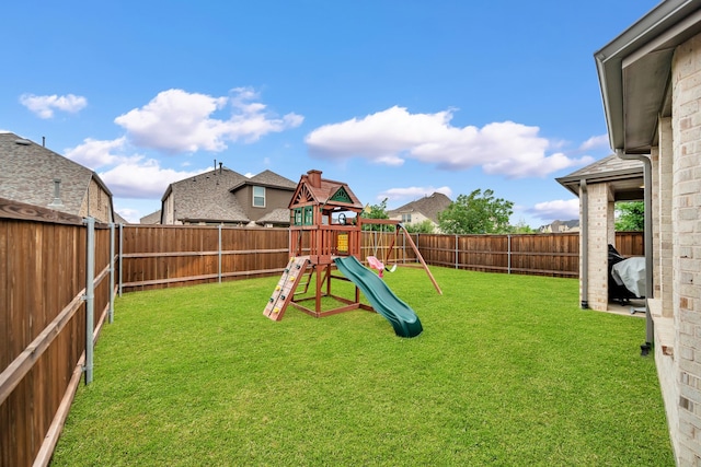 view of playground featuring a yard and a fenced backyard