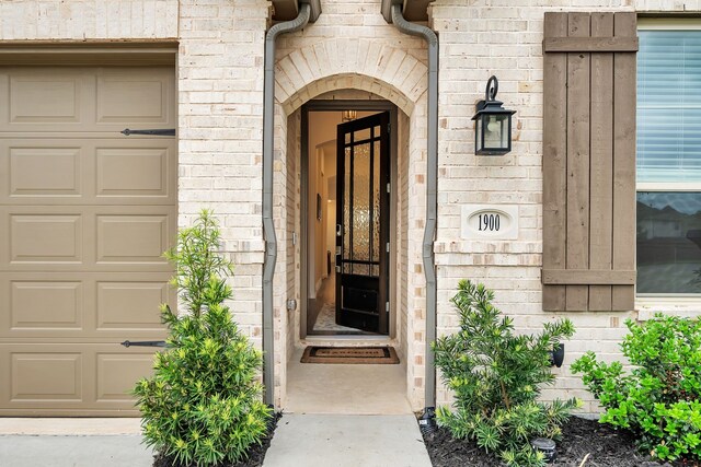 view of exterior entry featuring a garage and stone siding