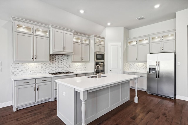 kitchen featuring visible vents, dark wood-style flooring, an island with sink, a sink, and appliances with stainless steel finishes