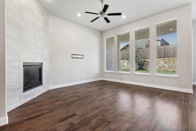 unfurnished living room with dark wood finished floors, a ceiling fan, baseboards, recessed lighting, and a tile fireplace