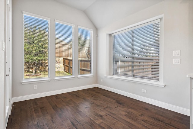 spare room with dark wood-style flooring, baseboards, and vaulted ceiling