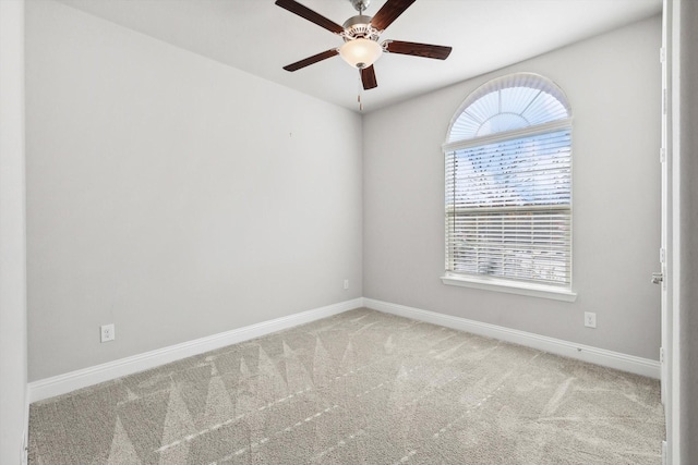 carpeted empty room with baseboards, plenty of natural light, and ceiling fan