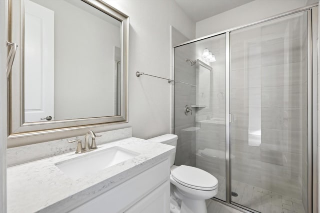 bathroom with vanity, a stall shower, and toilet
