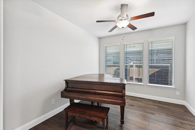 living area with baseboards, ceiling fan, and wood finished floors