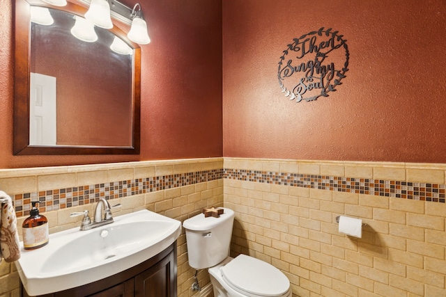 401 Willow Run, Prosper, TX 75078 - bathroom featuring a textured wall, toilet, vanity, tile walls, and a wainscoted wall