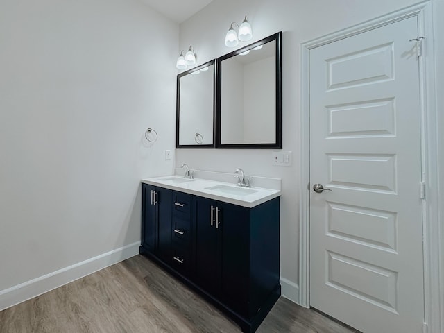 bathroom with baseboards, a sink, and wood finished floors