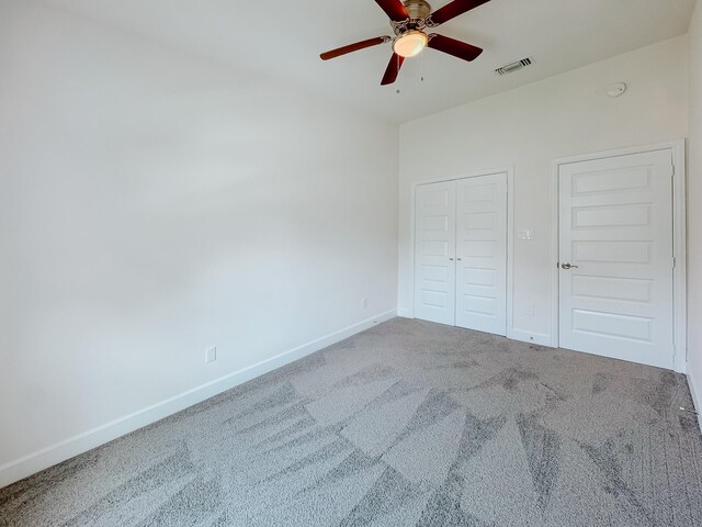 unfurnished bedroom with visible vents, a closet, baseboards, a ceiling fan, and carpet