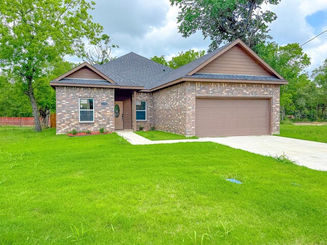 view of front of home featuring concrete driveway, brick siding, a front yard, and roof with shingles