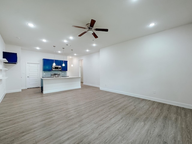 unfurnished living room with light wood-style floors, recessed lighting, baseboards, and ceiling fan