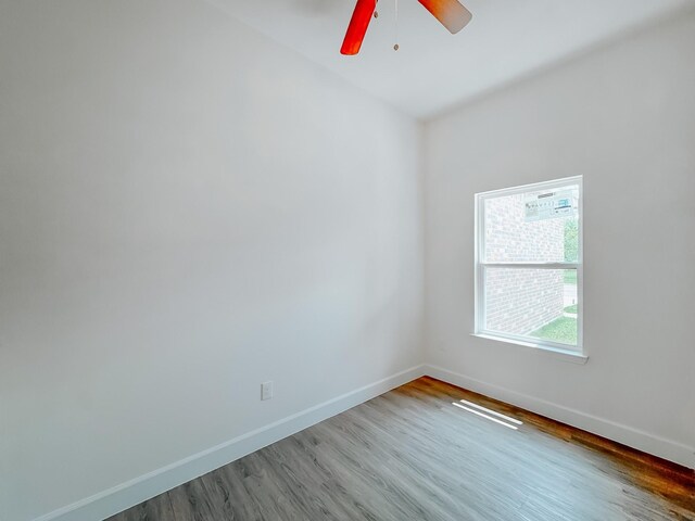 unfurnished room with baseboards, a ceiling fan, and wood finished floors
