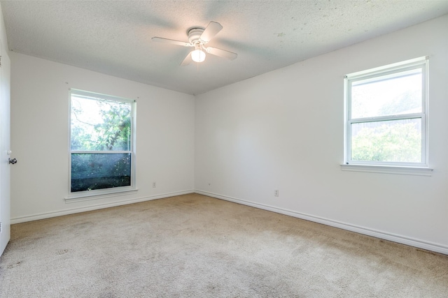 carpeted spare room with a ceiling fan, a textured ceiling, and baseboards