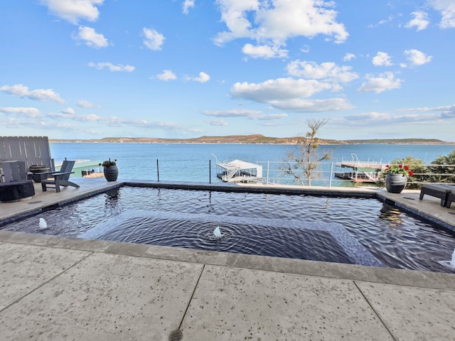 view of swimming pool featuring a water view and a boat dock